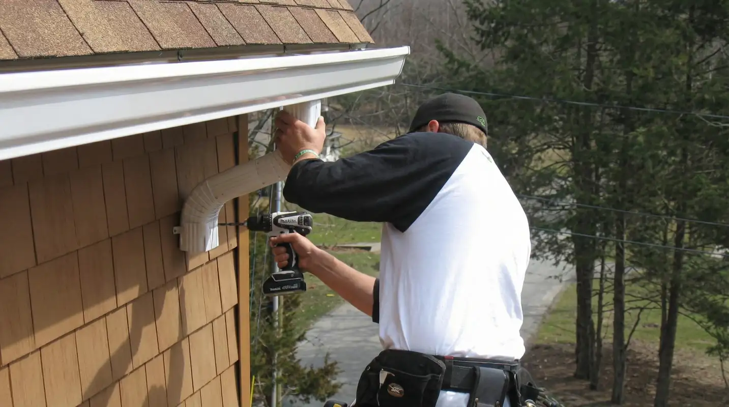 Professional contractor installing tan vinyl siding panels on a residential home exterior in Boca Raton, FL